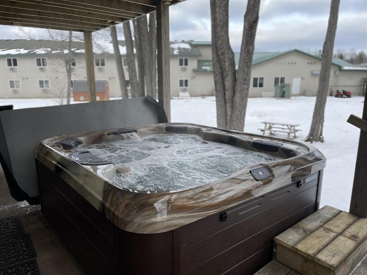 Hot tub under upper deck on back patio