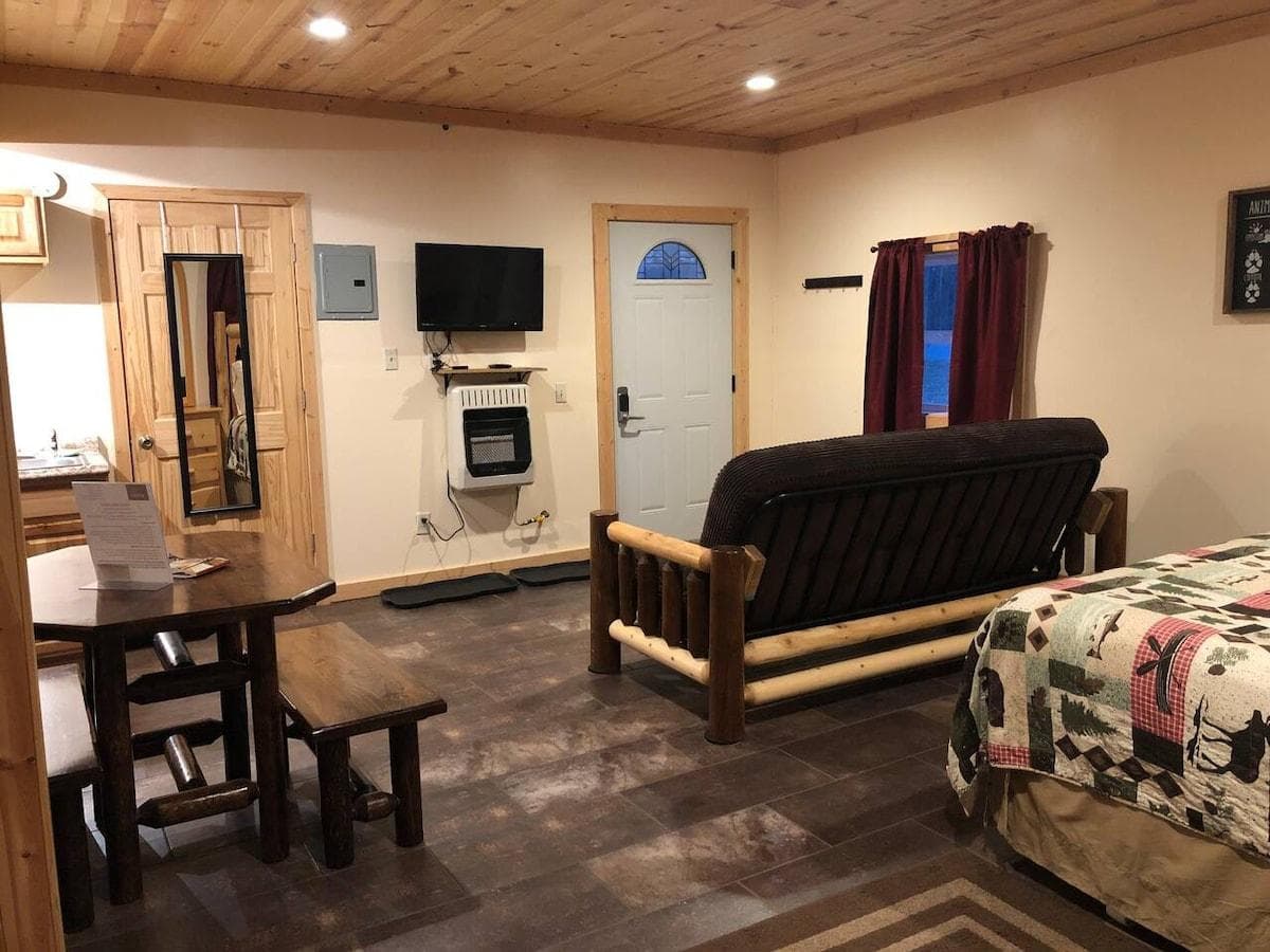 Entry door and couch with TV that includes Netflix and Amazon subscriptions